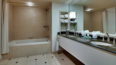 hotel bathroom with bathtub and double sink vanity