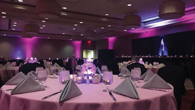 A circular table covered in a pink table cloth with gray napkins inside the banquet space at Hollywood Casino in St. Louis, Missouri.