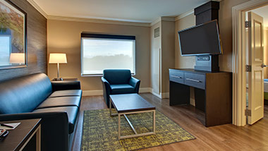 hotel suite with couch, sitting chair, tv