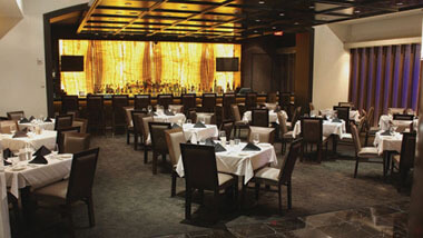 Four-top tables covered in white table cloths inside Final Cut Steakhouse at Hollywood Casino in St. Louis, Missouri.