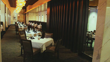 A long row of tables  set for 4 each inside Final Cut Steakhouse at Hollywood Casino in St. Louis, Missouri.