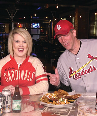 Man and woman laughing and wearing baseball clothing