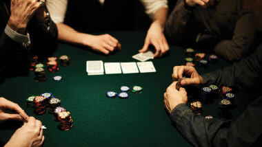 Hands, chips and cards on a poker table