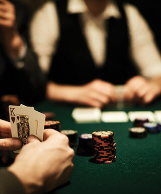 hands playing cards at table with cards and chips